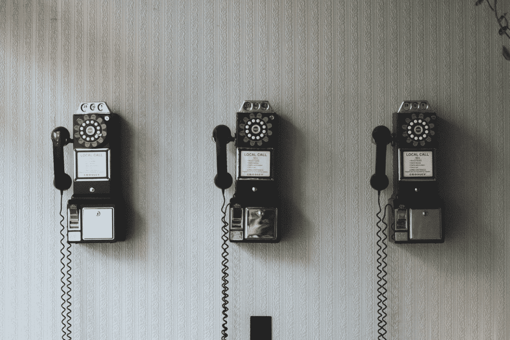 Three vintage telephones on wall